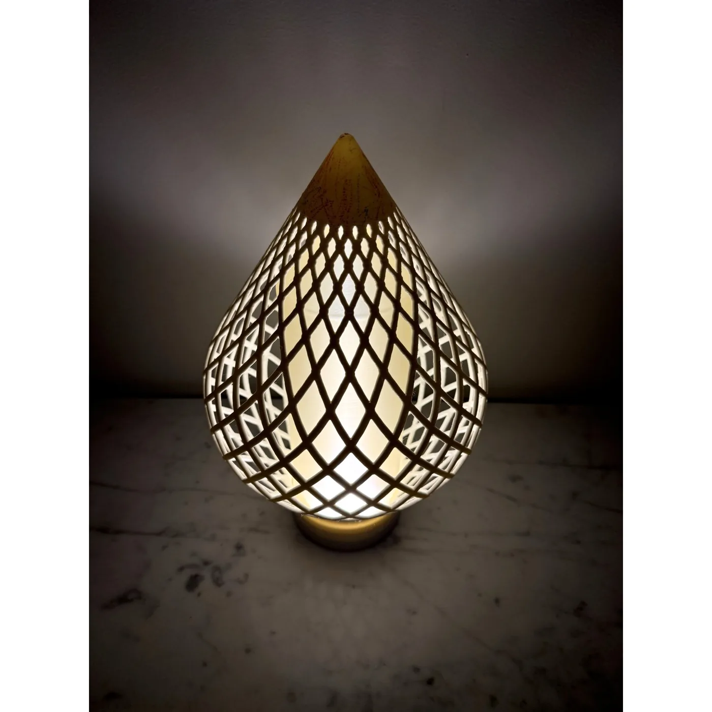 Reef Diagrid lit in a dark room: the woven diamond shell glowing over its frosted core