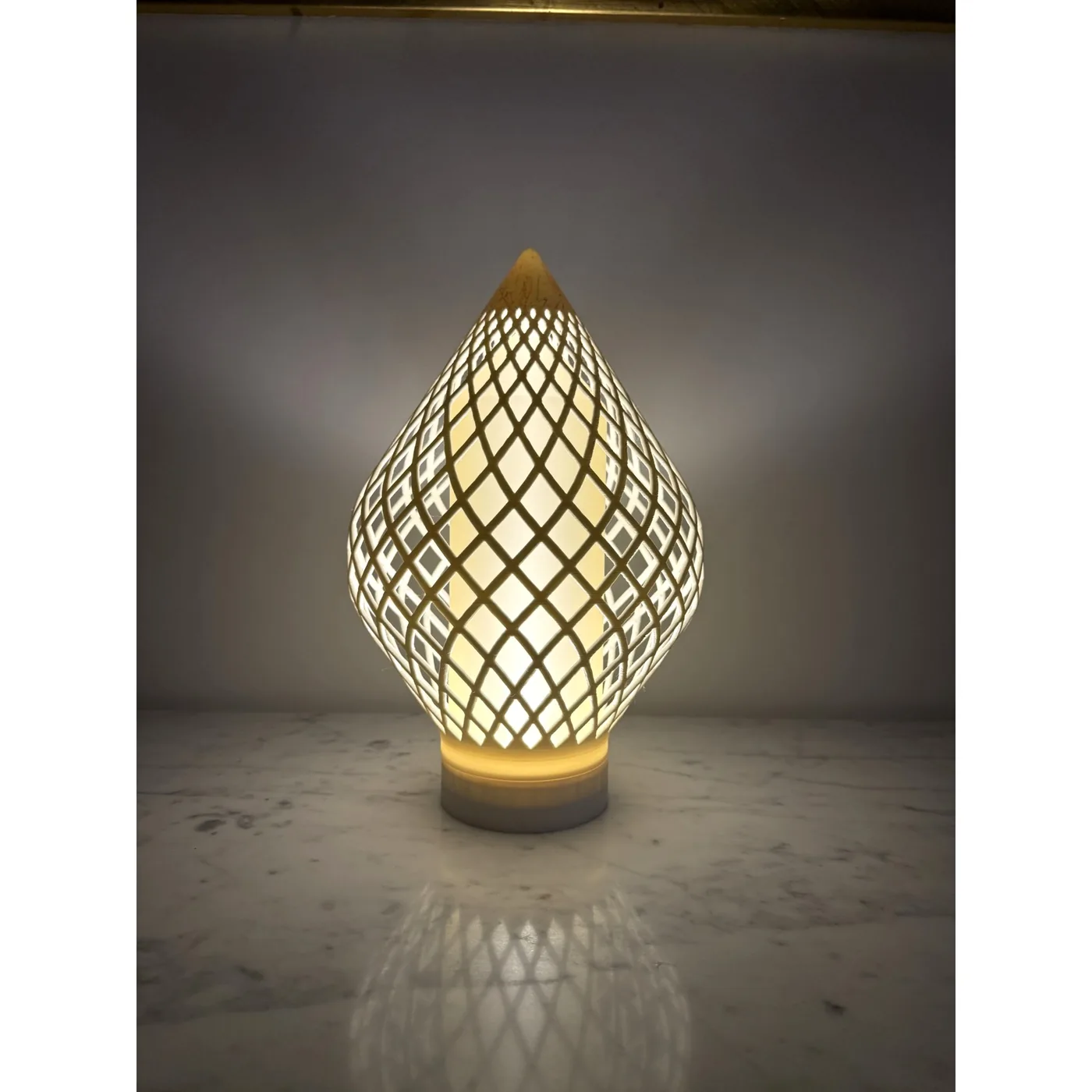 Reef Diagrid lit, three-quarter view on a marble surface
